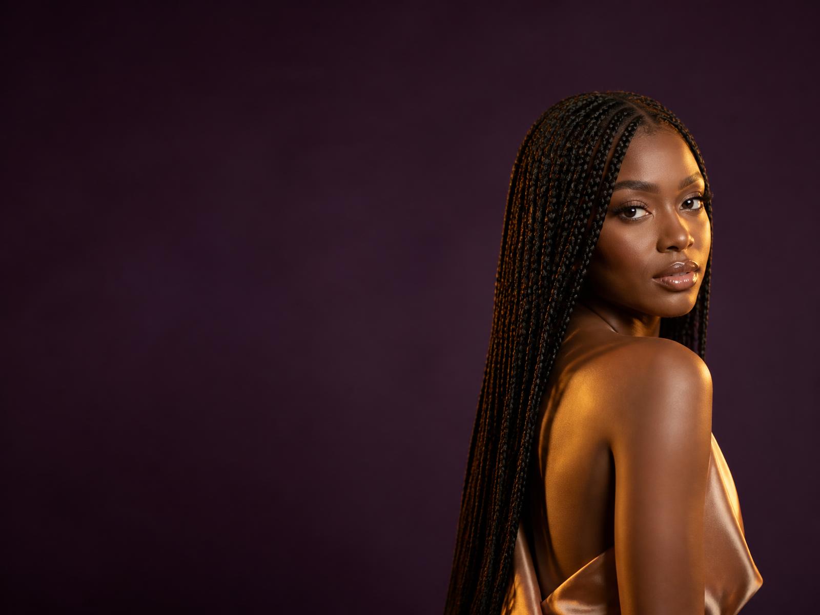 Model with a sleek HD lace front wig and gold jewellery
